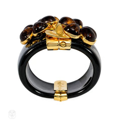 Chunky black acrylic cuff with amber crystal flower motif. Simon Harrison